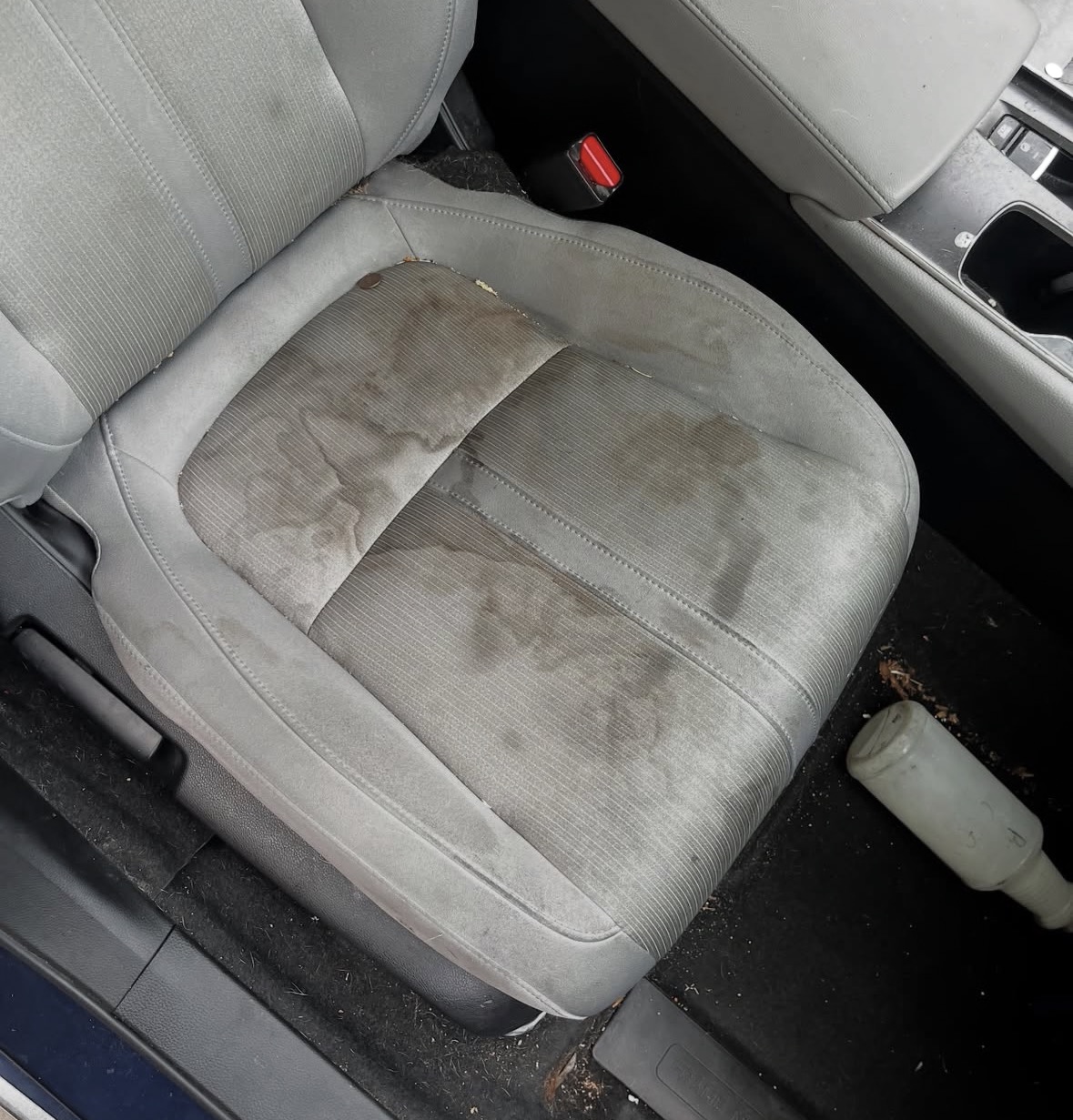 Heavily stained car seat before detailing